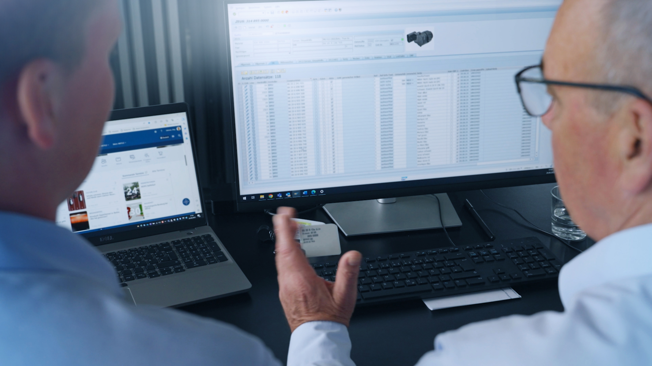 Two people sit in front of screens and maintain MEYLE data.