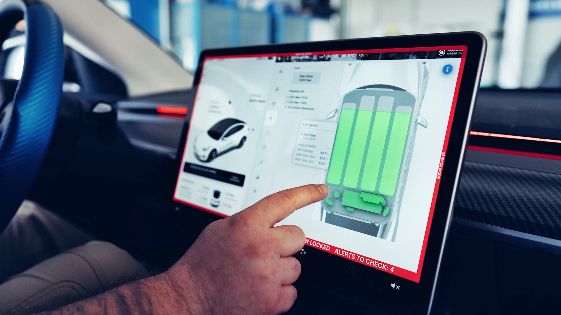 Close up von Händen in E-Auto Schutzhandschuhen, die etwas an der Hochvoltbatterie machen.