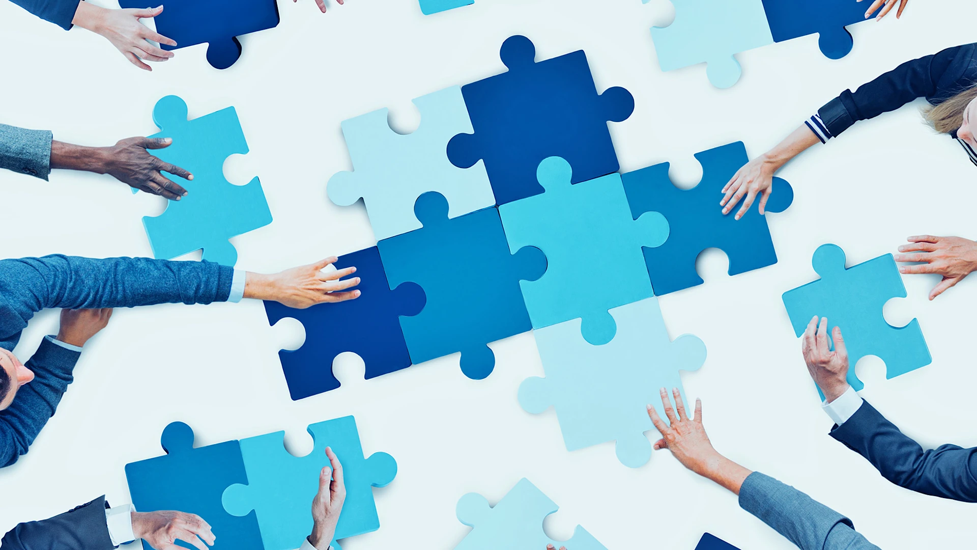 People put large blue puzzle pieces together.