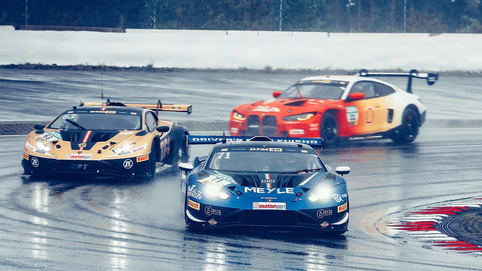 Three racing cars on a wet track in the bend, the MEYLE Lamborghini is in front.