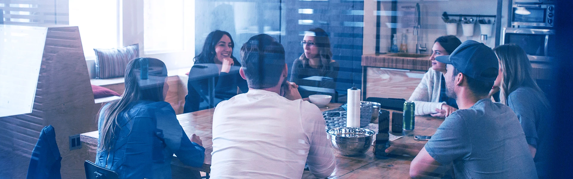 Seven young people sitting around a table.