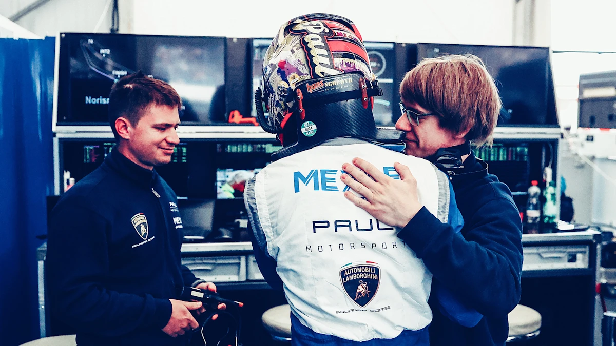 Max Paul ist von hinten zu sehen und wird von Teamkollegen umarmt.