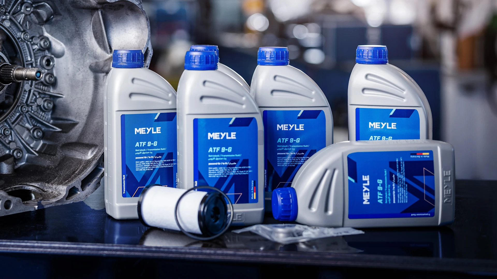 Photo of MEYLE engine oil bottles with the new labels in a workshop setting.