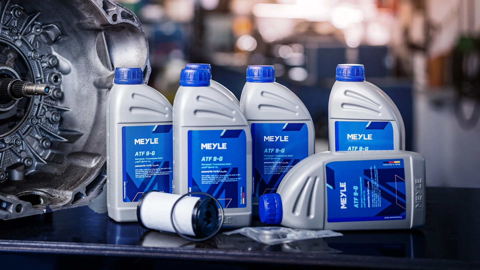 Photo of MEYLE engine oil bottles with the new labels in a workshop setting.