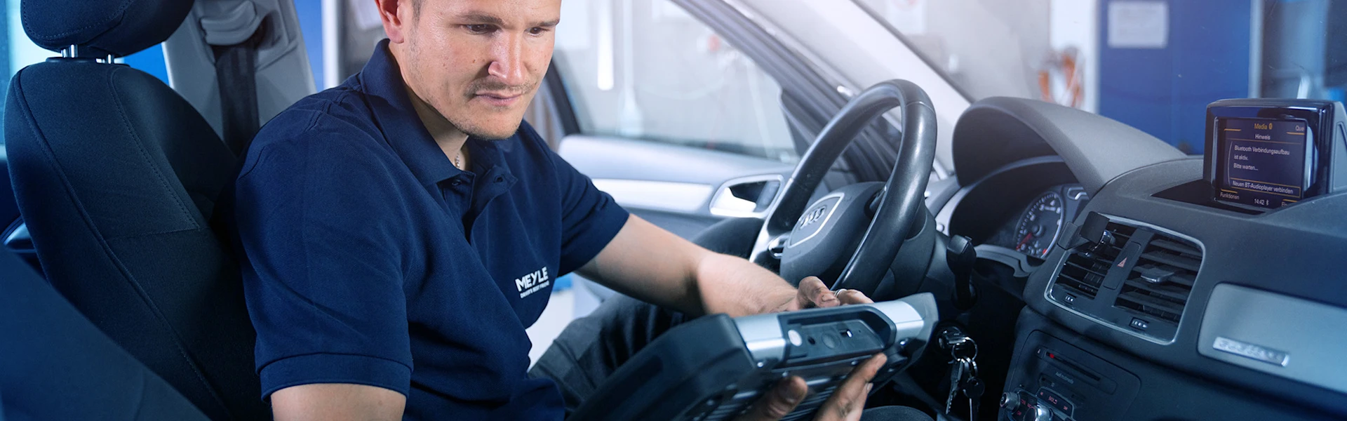 Mechanic sits in the car and reads out data.