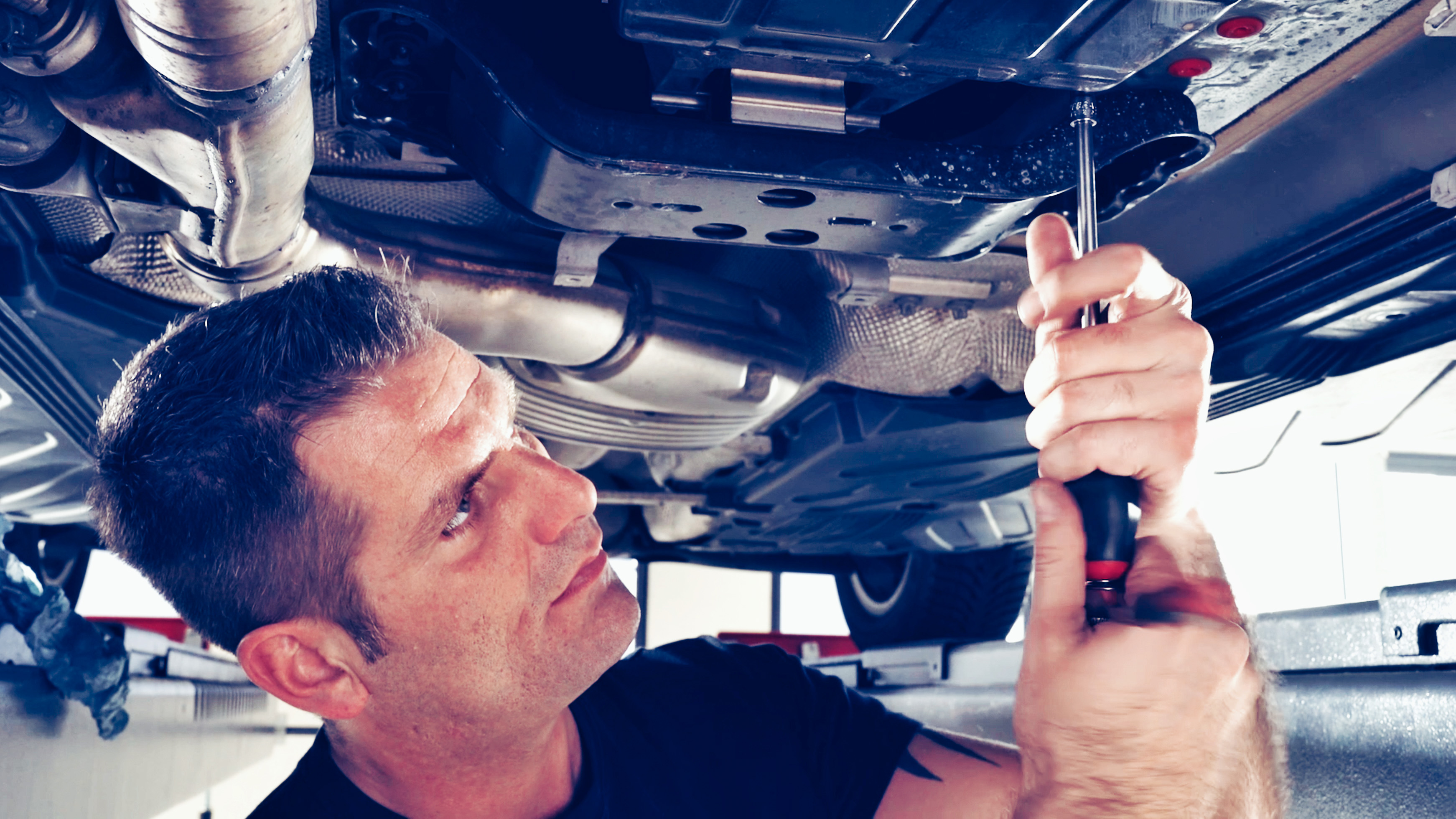 Mechanic flushes the transmission during a transmission oil change.