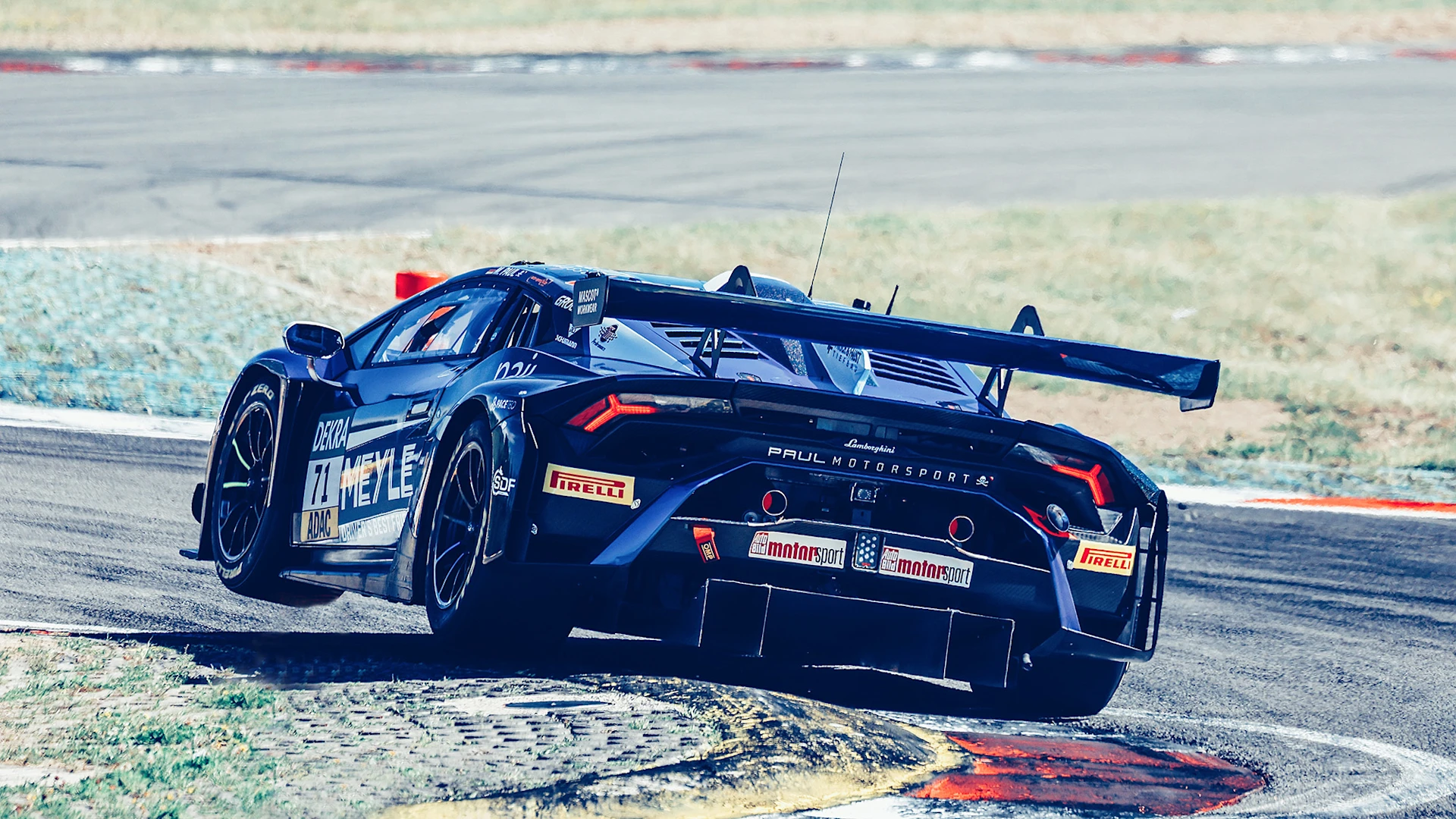 Racing car on the track from behind, drives into a sharp bend and lifts off with the front tire.