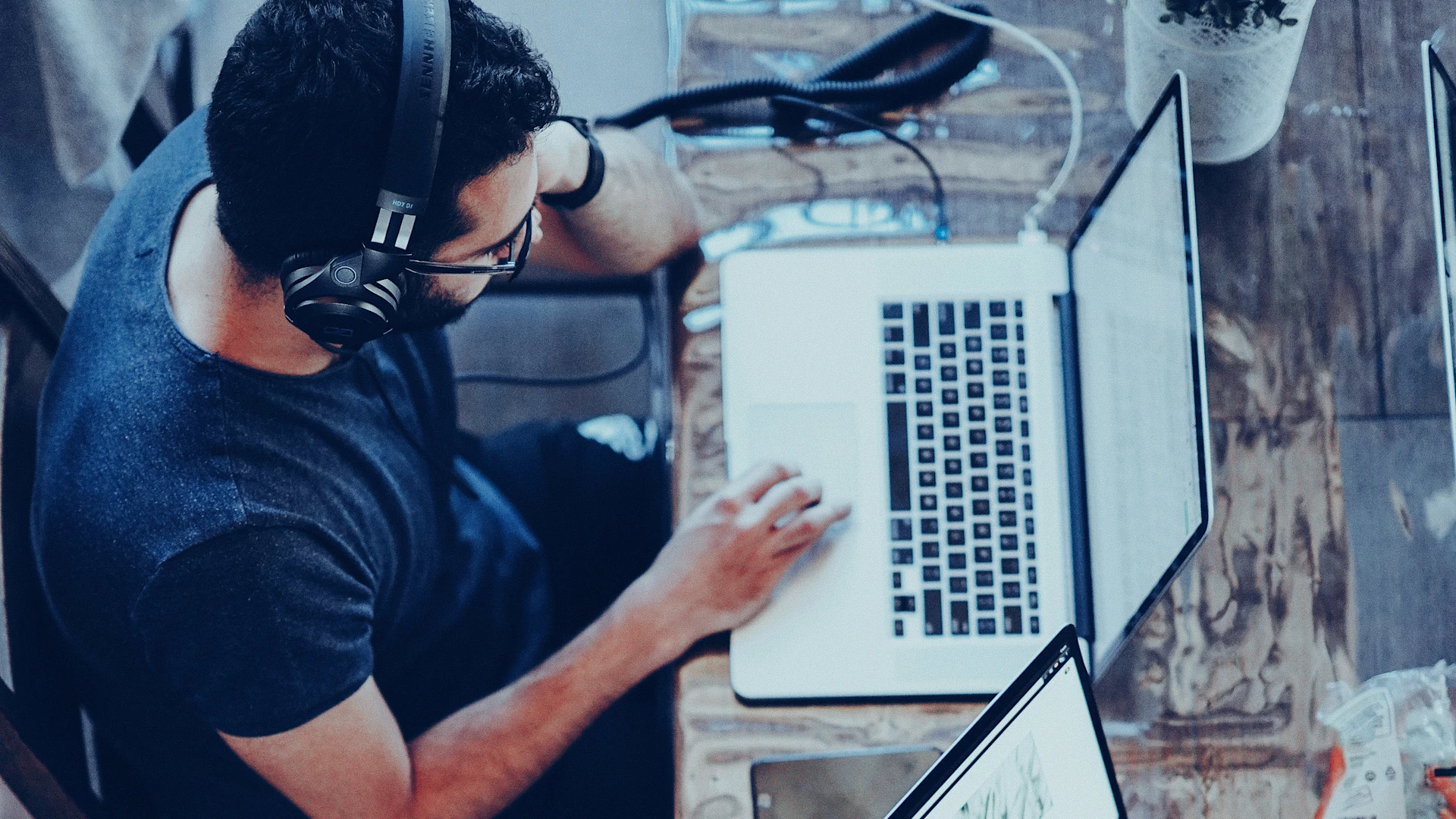 Bird's eye view: person working on a laptop with headphones.