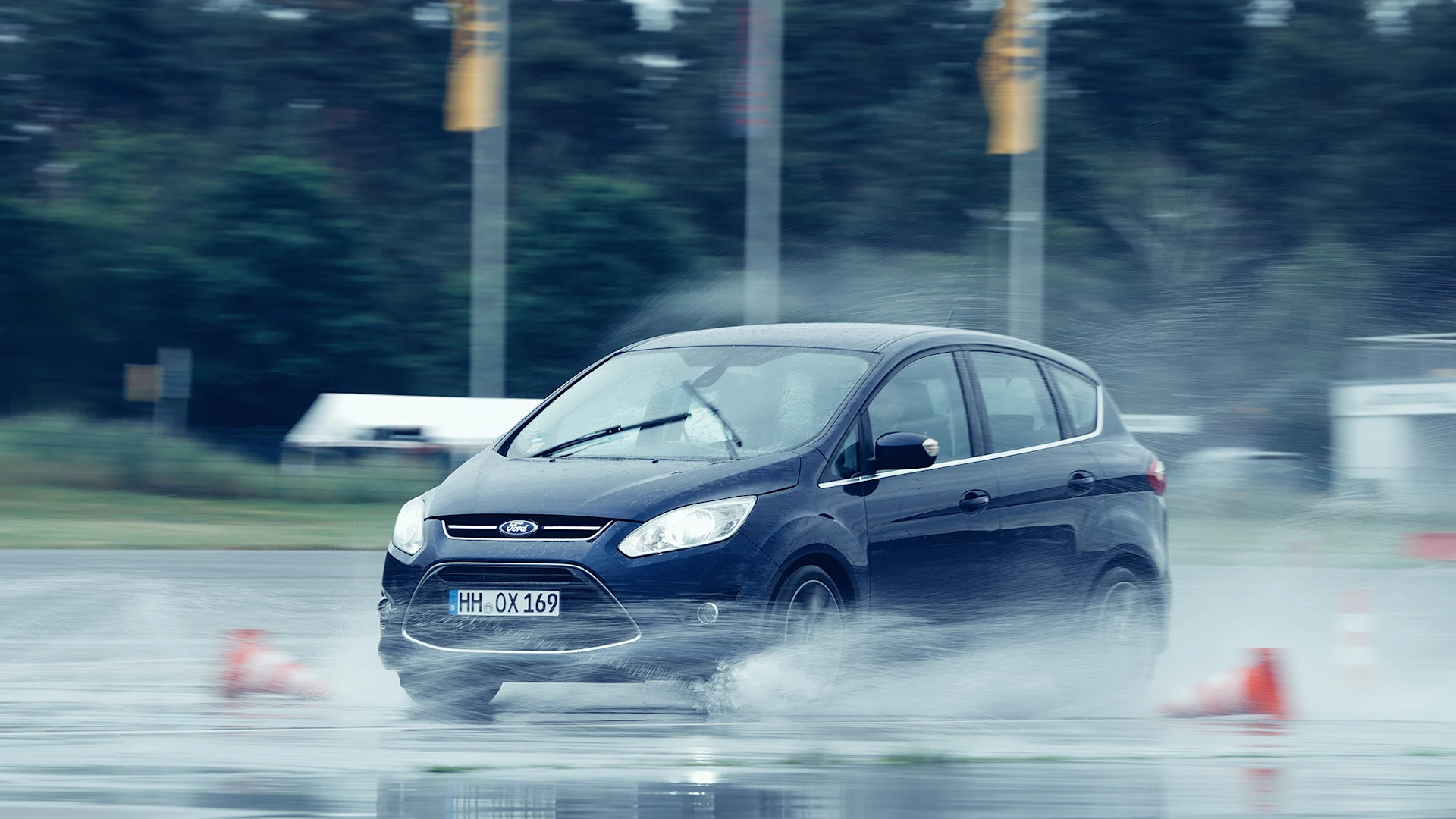 A car drives on a wet test track.
