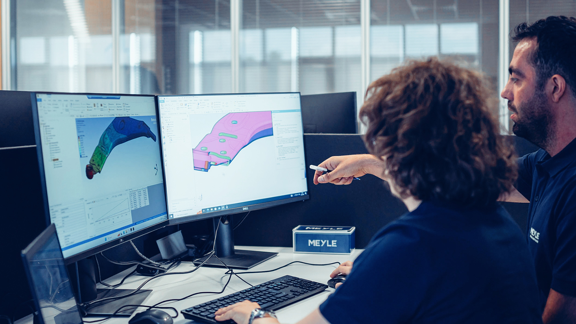 Zwei Personen sitzen vor Bildschirmen und entwickeln einen Prototypen.