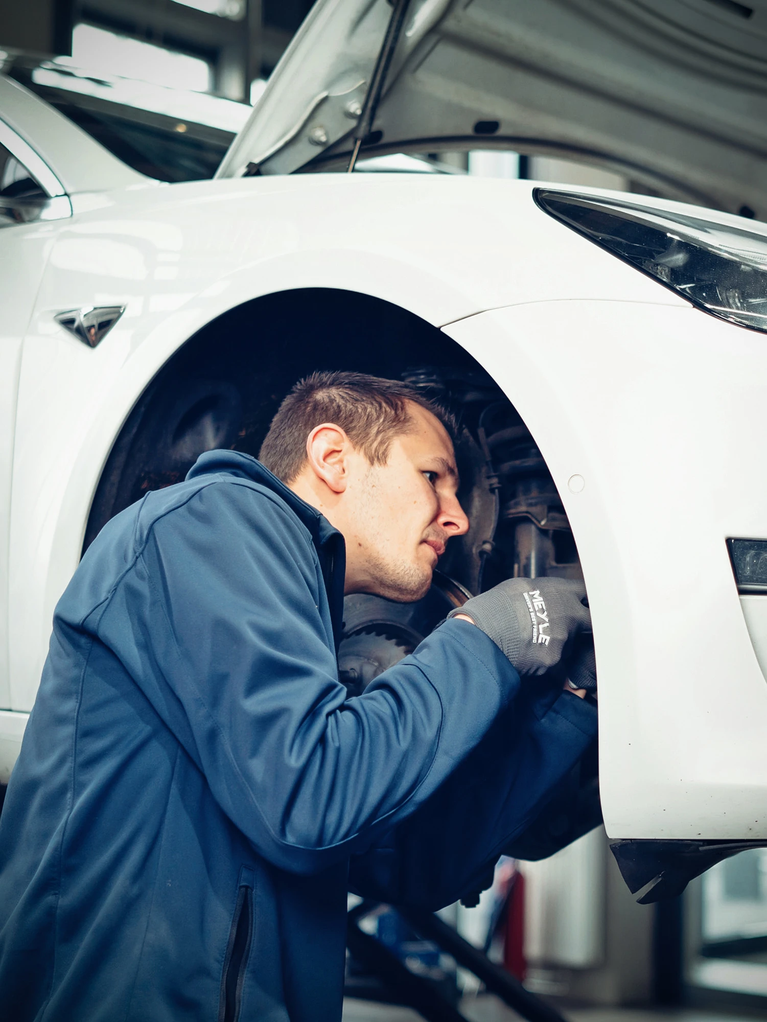Mechaniker prüft oder repariert etwas an Dämpfungsteilen.